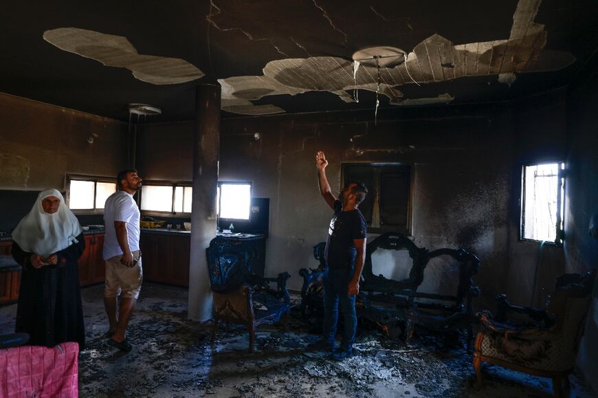 People check damage to their home after an attack by Jewish settlers on the West Bank village of Jit