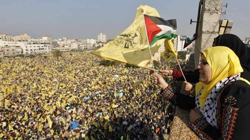 Women wave Palestinian (front) and Fatah flags during a rally marking the 48th anniversary of the founding of the Fatah movement, in Gaza City January 4, 2013. Hundreds of thousands of Palestinians joined a rare rally staged by President Mahmoud Abbas's Fatah group in Gaza on Friday, as tensions ease with rival Hamas Islamists ruling the enclave since 2007. REUTERS/Mohammed Salem (GAZA - Tags: POLITICS ANNIVERSARY) - RTR3C3HR