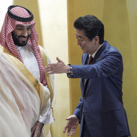 Saudi Arabia's Crown Prince Mohammed bin Salman (L) is escorted by Japanese Prime Minister Shinzo Abe, who was killed on July 8, 2022, during their meeting in Osaka, Japan, June 30, 2019.