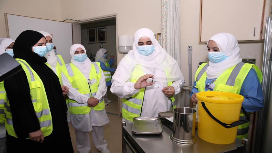 A healthcare worker prepares to administer the Pfizer-BioNTech COVID-19 vaccine in the Omani capital Muscat on December 27, 2020. (Photo by MOHAMMED MAHJOUB / AFP) (Photo by MOHAMMED MAHJOUB/AFP via Getty Images)