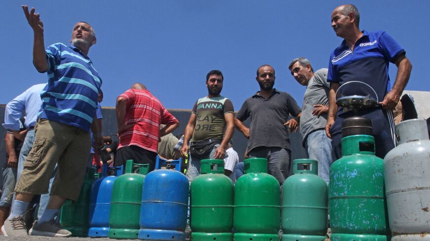 TOPSHOT - Lebanese wait to fill their gas cylinders in the southern city of Sidon amidst a deepening economic crisis, on August 10, 2021 - Lebanese lined up in long queues to stock up on cooking gas following warnings of imminent shortages, as an economic crisis eats away at supplies of basic imports.Lebanon, grappling with an economic crisis branded by the World Bank as one of the planet's worse since the mid-19th century, has been hit in recent months by a wave of shortages of basic items from medicine to