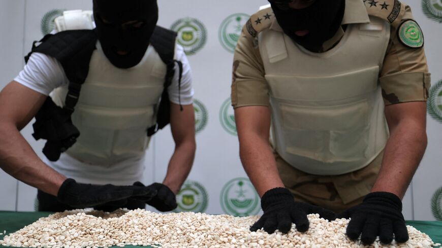 Officers of the Directorate of Narcotics Control of Saudi Arabia's Interior Ministry sort through tablets of Captagon.