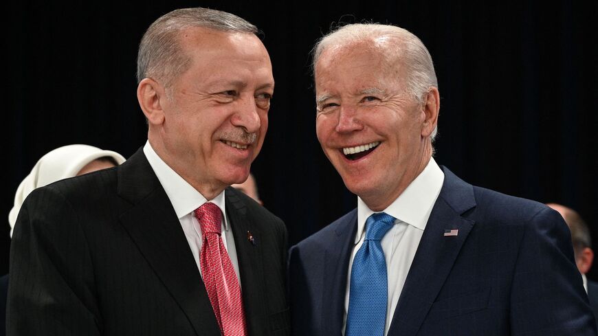 Turkey's President Recep Tayyip Erdogan (L) and US President Joe Biden shake hands at the start of the first plenary session of the NATO summit at the Ifema congress centre in Madrid, on June 29, 2022. 