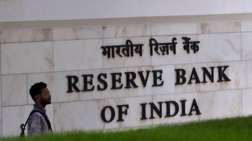 A man walks past a sign of the Reserve Bank of India (RBI) in Mumbai on August 5, 2022. - India's central bank on August 5 hiked interest rates for the third time in four months, as Asia's third-largest economy contends with a widening trade deficit and weakening currency. (Photo by Indranil MUKHERJEE / AFP) (Photo by INDRANIL MUKHERJEE/AFP via Getty Images)