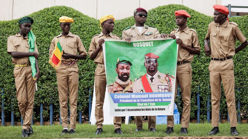 Supporters hold a poster depicting Malis interim leader and head of Junta, Colonel Assimi Goïta (L) and Guinea Interim leader and head of Junta, Mamady Doumbouya (R), in Bamako, Mali, on September 22, 2022 during Mali's Independence Day military parade. (Photo by OUSMANE MAKAVELI / AFP) (Photo by OUSMANE MAKAVELI/AFP via Getty Images)