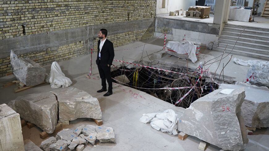 A man looks at artifacts, under restoration after being destroyed by the Islamic State (IS) group, at the Mosul Museum in Iraq's northern city on May 11, 2023.