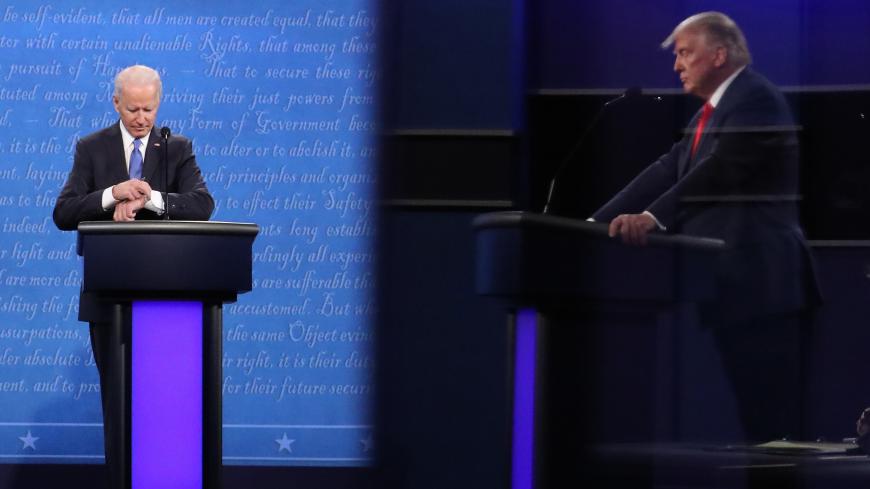 NASHVILLE, TENNESSEE - OCTOBER 22:  Democratic presidential nominee Joe Biden checks his watch during the final presidential debate against U.S. President Donald Trump (shown in reflection) at Belmont University on October 22, 2020 in Nashville, Tennessee. This is the last debate between the two candidates before the election on November 3. (Photo by Chip Somodevilla/Getty Images)