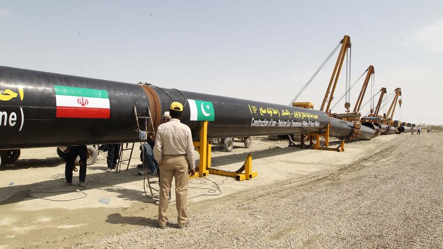 An Iranian worker stands in front of a section of a pipeline after the project was launched during a ceremony with presidents of Iran and Pakistan on March 11, 2013 in the Iranian border city of Chah Bahar.ATTA KENARE/AFP via Getty Images)