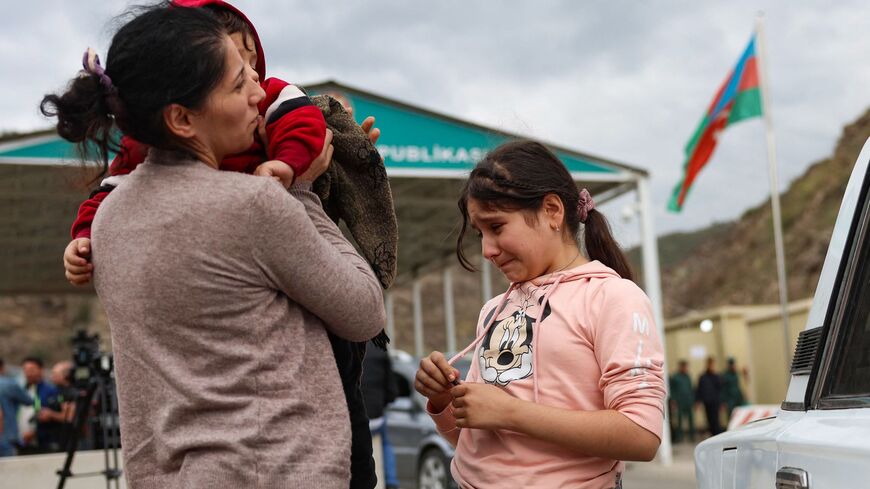 A refugee and her children waits at the Lachin checkpoint to leave Karabakh for Armenia, on Sept. 26, 2023. 