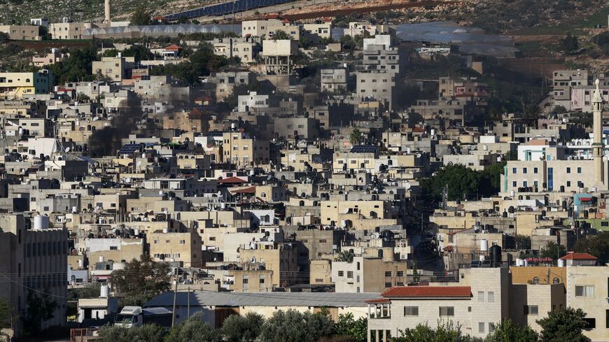 Black smoke billows amid clashes as Israeli forces raid the al-Faraa camp for Palestinian refugees near Tubas city in the occupied West Bank on Jan. 13, 2024.