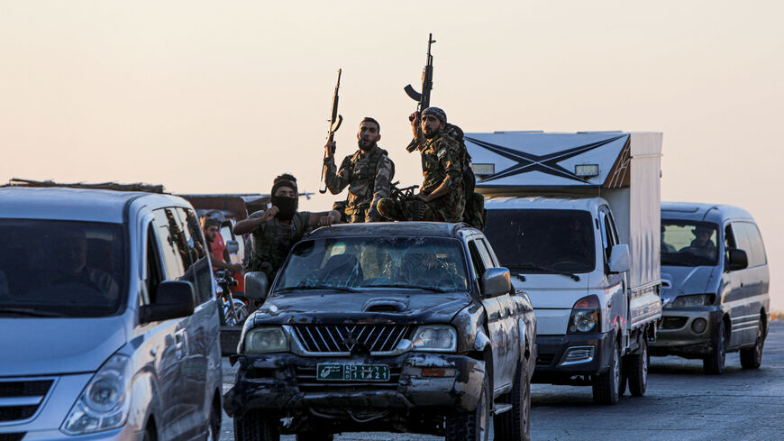 Armed men drive in the back of a pick up truck during protests against Turkey in al-Bab, in the northern Syrian opposition held region of Aleppo on July 1, 2024. A man was killed after and Turkish forces clashed in Syria's Ankara-controlled northwest, a war monitor said, in demonstrations sparked by violence against Syrians in Turkey a day earlier. (Photo by Bakr ALKASEM / AFP) (Photo by BAKR ALKASEM/AFP via Getty Images)