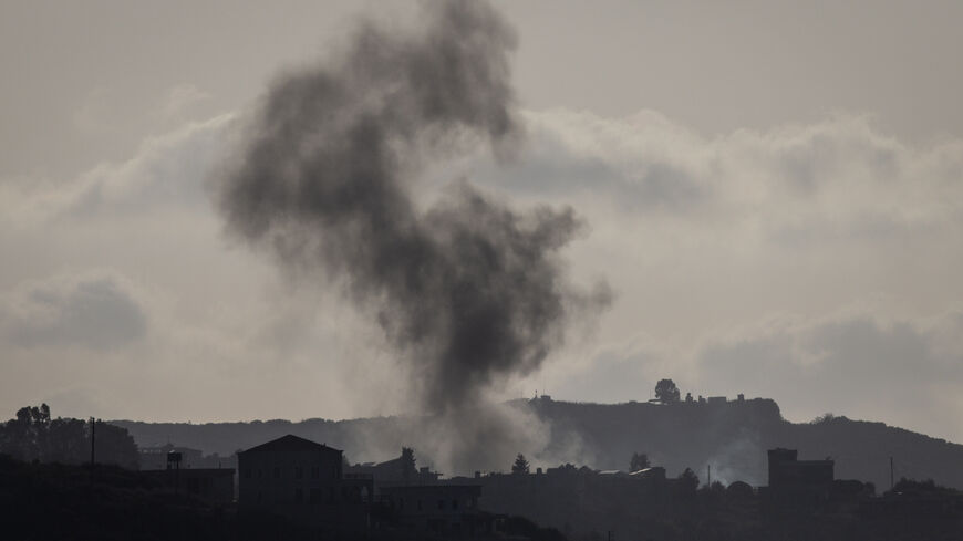 RMAICH, LEBANON - JUNE 30: Smoke rises behind buildings from an Israeli strike against a Hezbollah target on the town of Aita al Chaab on June 30, 2024 in Rmaich, Lebanon. Hezbollah and the Israeli Defense Forces (IDF) have been trading cross-border fire since the October 7 attacks, with the conflict escalating in May when the group launched a missile-carrying drone against Israel for the first time. The conflict intensified in June when Hezbollah fired hundreds of rockets and drones at Israeli military sit