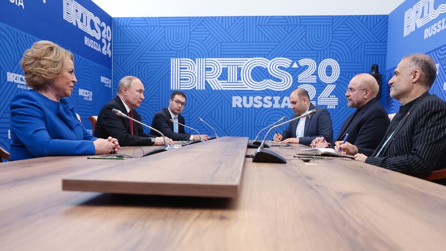 In this pool photograph distributed by the Russian state agency Sputnik, Russia's President Vladimir Putin (2L) meets with Iran's conservative Parliament Speaker Mohammad Bagher Ghalibaf (2R) on the sidelines of a BRICS (the bloc that includes Brazil, Russia, India, China and South Africa) parliamentary forum in Saint Petersburg on July 11, 2024. 