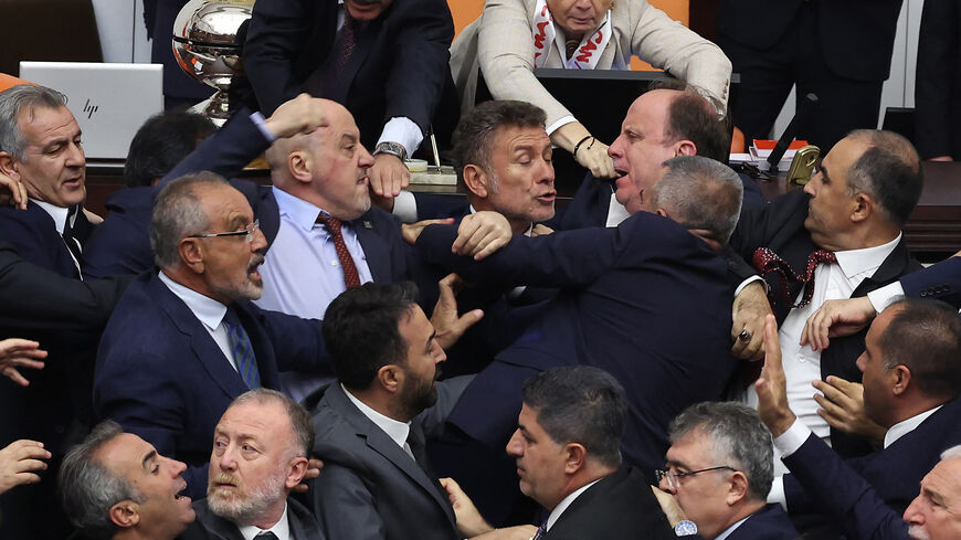 TOPSHOT - Turkish ruling and opposition lawmakers fight each other after a scuffle between former footballer Alpay Ozalan (unseen), a lawmaker from Erdogan's ruling AKP party and Turksih Workers Party (TIP) deputy Ahmet Sik (unseen) at Grand National Assembly of Turkey in Ankara on August 16,2024. A brawl broke out in Turkey's parliament on August 16, 2024, after lawmakers convened to discuss the status of a jailed opposition figure controversially stripped of his parliamentary immunity earlier this year. T