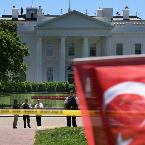 Members of the Secret Service stand guard as people wave Turkish flags during a rally in front of the White House in Washington,DC on May 16, 2017. 