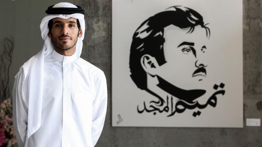 Qatari artist Ahmed Bin Majed Al-Maadheed stands next to his painting of Qatari Emir Tamim bin Hamad al-Thani titled "Glorious Tamim" at a gallery in Doha on July 28, 2017.  
Maadheed's painting of the Qatari Emir has been spread widely on social media since Saudi Arabia, Bahrain, the United Arab Emirates and Egypt broke ties with Qatar on June 5, transforming the artist into a star.  / AFP PHOTO / STRINGER / RESTRICTED TO EDITORIAL USE - MANDATORY MENTION OF THE ARTIST UPON PUBLICATION - TO ILLUSTRATE THE 