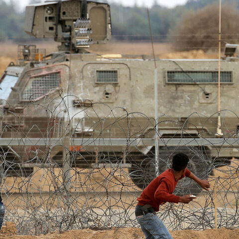 Palestinian demonstrators hurl stones at Israeli troops during an anti-Israel protest at the Israel-Gaza border fence in the southern Gaza Strip October 25, 2019. REUTERS/Ibraheem Abu Mustafa - RC1C46E0D630