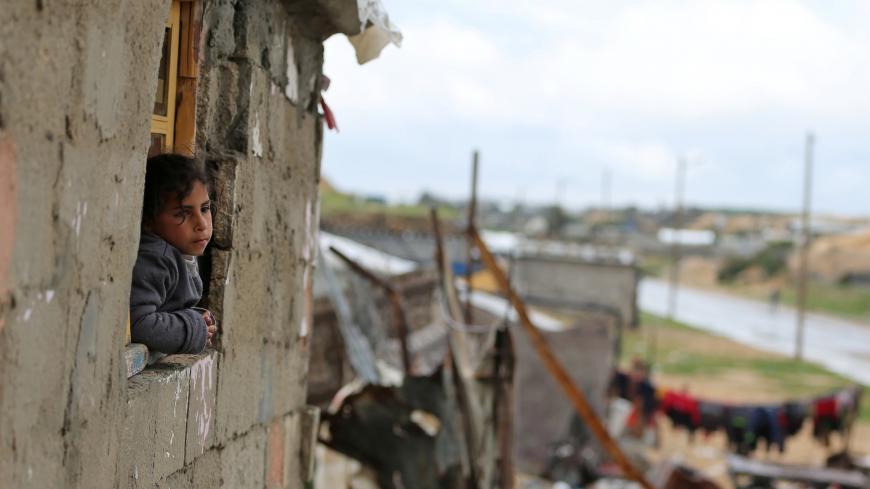 A Palestinian girl looks out of her family dwelling on a rainy winter day in Khan Younis in the southern Gaza Strip February 10, 2020. REUTERS/Ibraheem Abu Mustafa - RC2KXE9KDOS8