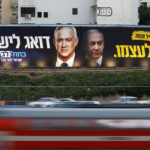 Traffic moves past a Blue and White party election campaign poster, depicting party leader Benny Gantz, and Israeli Prime Minister Benjamin Netanyahu, in Tel Aviv, Israel February 18, 2020. REUTERS/Amir Cohen - RC243F9KEJJJ