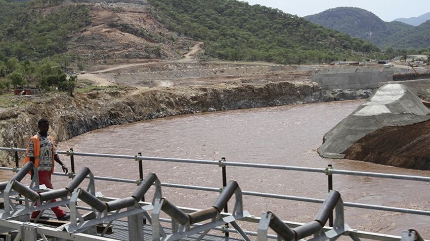 A man walks over a bridge by the construction of Ethiopia's Great Renaissance Dam in Guba Woreda, some 40 km (25 miles) from Ethiopia's border with Sudan, June 28, 2013. Egypt fears the $4.7 billion dam, that the Horn of Africa nation is building on the Nile, will reduce a water supply vital for its 84 million people, who mostly live in the Nile valley and delta. Picture taken June 28, 2013. REUTERS/Tiksa Negeri (ETHIOPIA - Tags: POLITICS SOCIETY ENERGY ENVIRONMENT) - RTX115K9