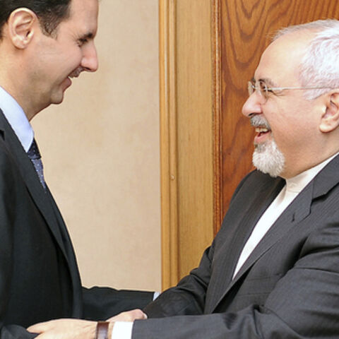 Syria's President Bashar al-Assad (L) welcomes Iran's Foreign Minister Mohammad Javad Zarif before a meeting in Damascus January 15, 2014, in this handout released by Syria's national news agency SANA. REUTERS/SANA/Handout via Reuters (SYRIA - Tags: POLITICS CONFLICT TPX IMAGES OF THE DAY) ATTENTION EDITORS - THIS IMAGE WAS PROVIDED BY A THIRD PARTY. FOR EDITORIAL USE ONLY. NOT FOR SALE FOR MARKETING OR ADVERTISING CAMPAIGNS. THIS PICTURE WAS PROCESSED BY REUTERS TO ENHANCE QUALITY. AN UNPROCESSED VERSION W